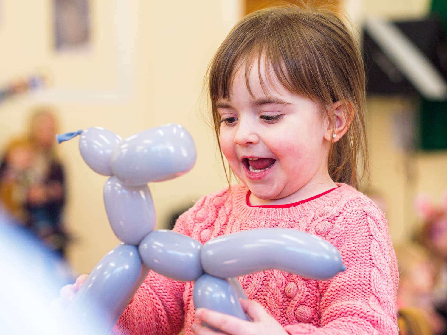 A child happy with their dog balloon